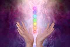 Female healer's hands either side of seven chakra vortexes